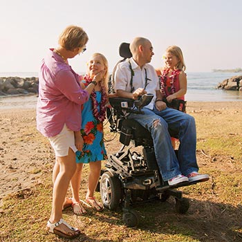 Man on wheelchair enjoying beach day with family