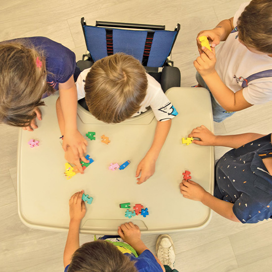 Child using Grillo Chair surrounded by school mates working on activity